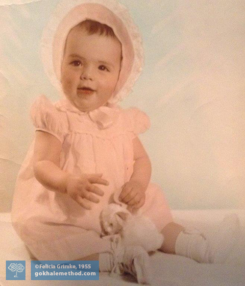 Felicia Grimke as a baby, stacksitting, dressed in pink.