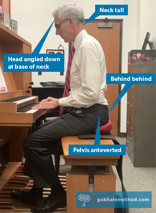 Photograph of David Pickering playing the organ, pelvis anteverted on Gokhale® Wedge.