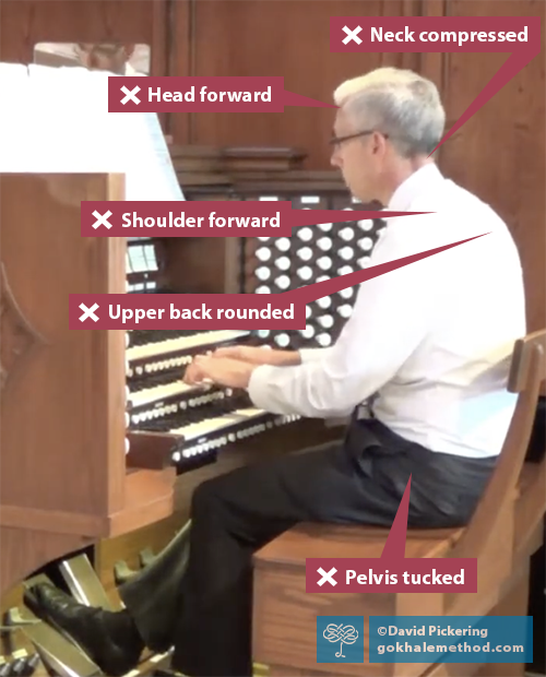 Photograph of David Pickering playing the organ, pelvis tucked, shoulders and head forward, facing left.