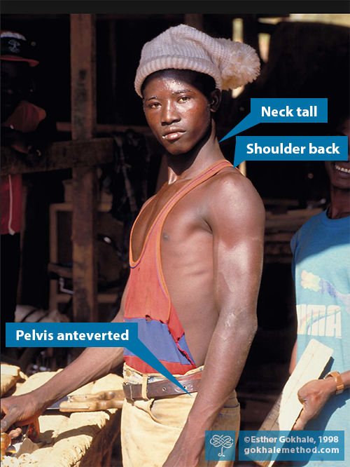 African carpenter standing by bench with well aligned posture.