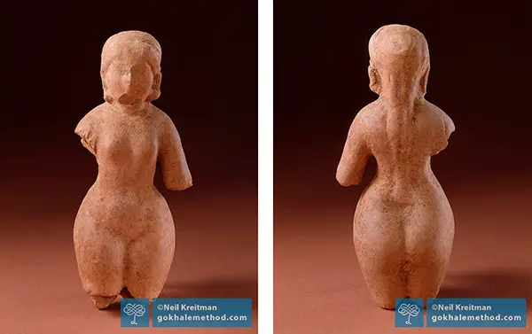Woman with healthy posture resting her hands on her lower belly.