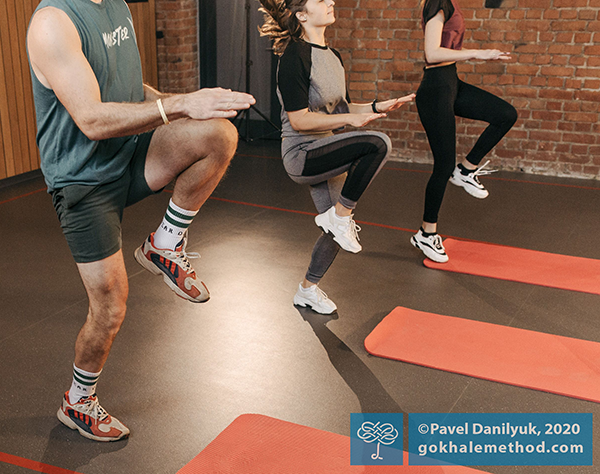 People exercising by lifting one knee high and holding their pelvises level