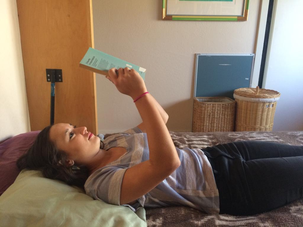 Girl holding book up, straining wrist and forearm muscles