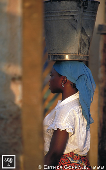 Woman head loading water, Ouahigouya, Burkina Faso, side view
