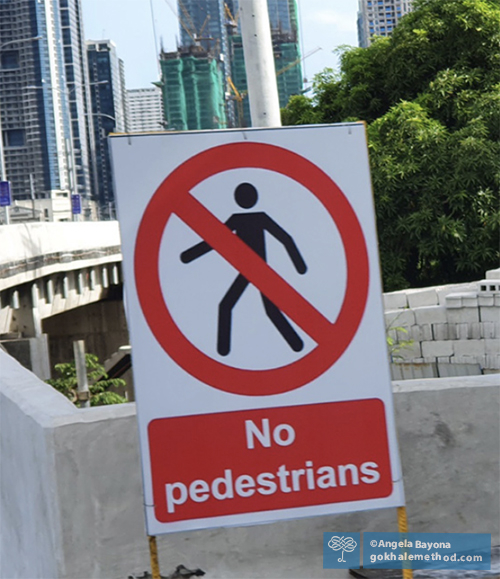 No entry sign showing walking figure, with both legs bent.