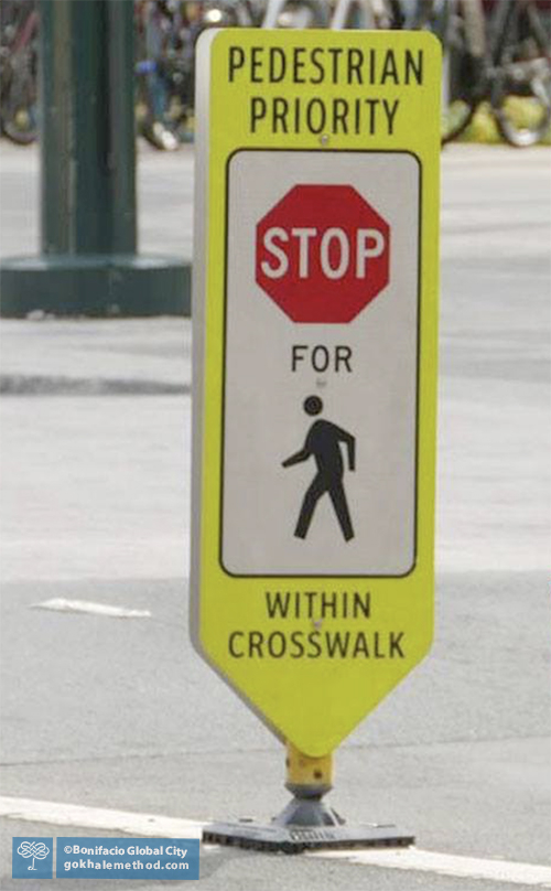Stop sign showing walking figure, weight aligned with straight back leg.