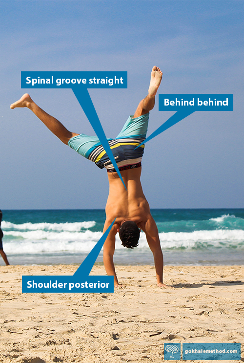 Man doing a carefree handstand on the beach. 