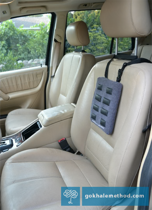 Photo of a Gokhale Stretchsit® Cushion fastened to a driver’s car seat.