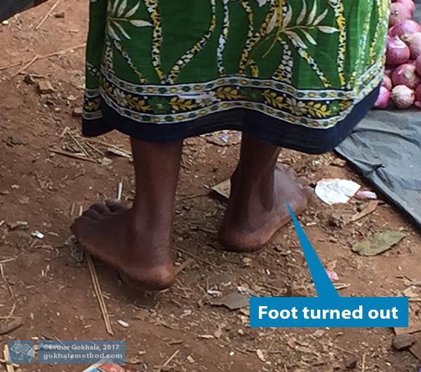 Woman in Odisha, bare feet pointed outward, close-up from behind 