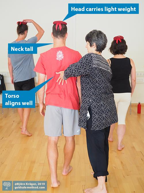 Student learning to head-load in glidewalking, guided by Esther Gokhale.