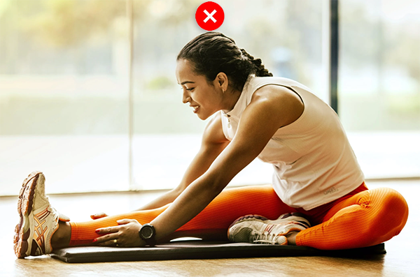 Yoga model in seated forward bend, side view, rounded back, compressed neck.