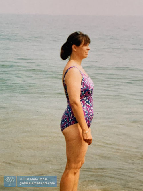 Julia Rabin aged 40 standing by shallow sea.