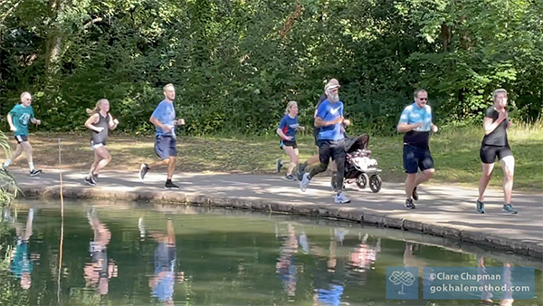 Park runners alongside lake