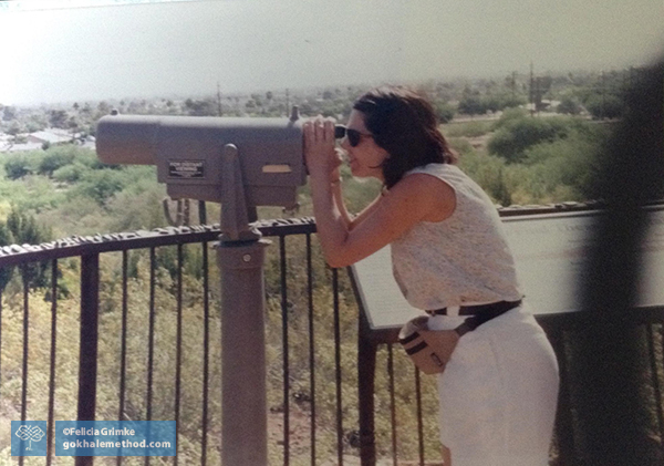 Felicia Grimke looks through telescope, hunching, side view.