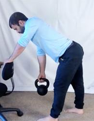 Gokhale Method Fitness teacher Eric Fernandez demonstrates eccentric muscle contraction as he slowly lowers a kettlebell.